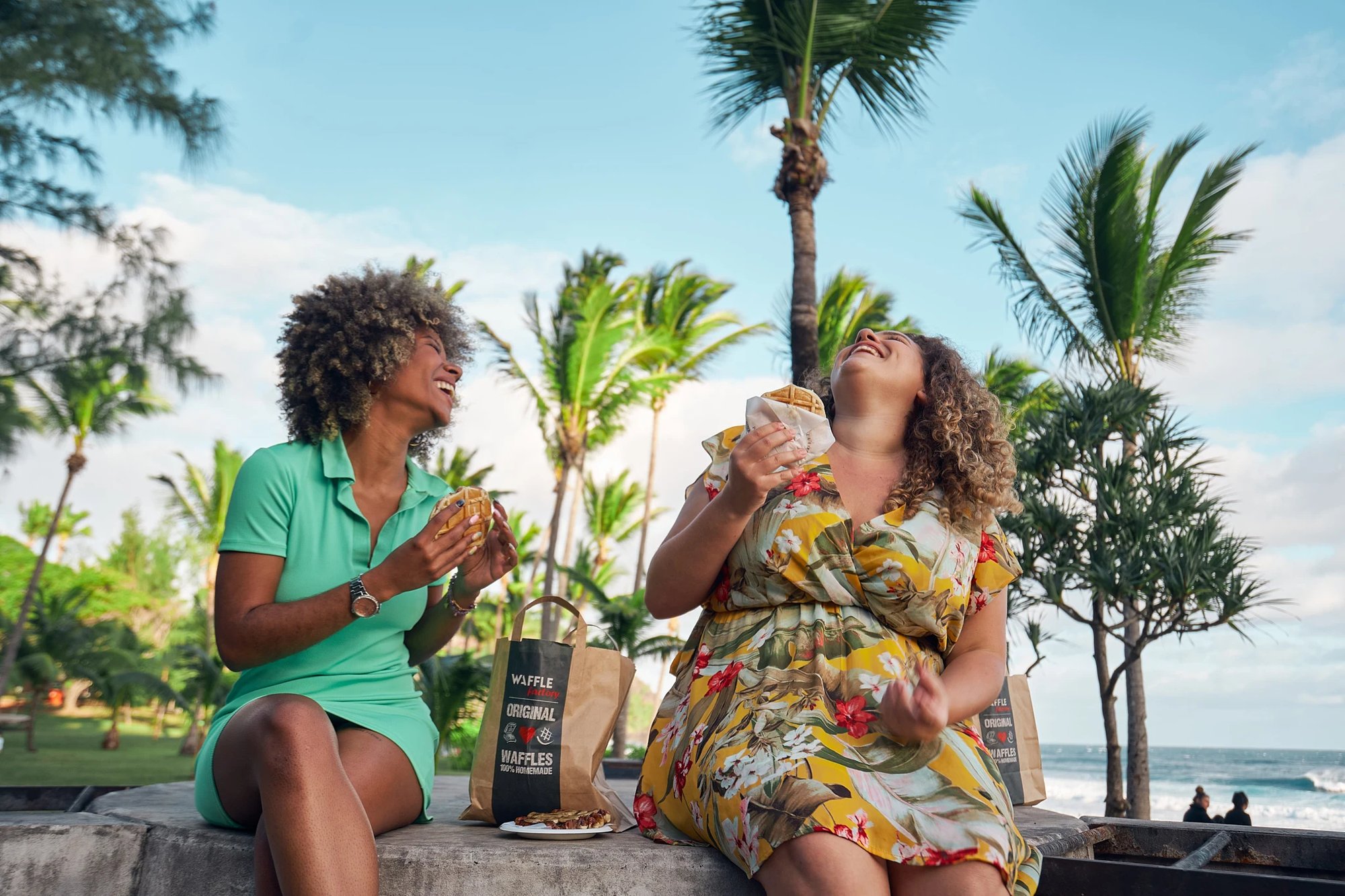 DEUX FEMMES RIGOLENT EN MANGEANT DES GAUFRES DE WAFFLE FACTORY A LA REUNION PLAGE DE GRAND ANSE - YOANN BOYER PHOTOGRAPHE